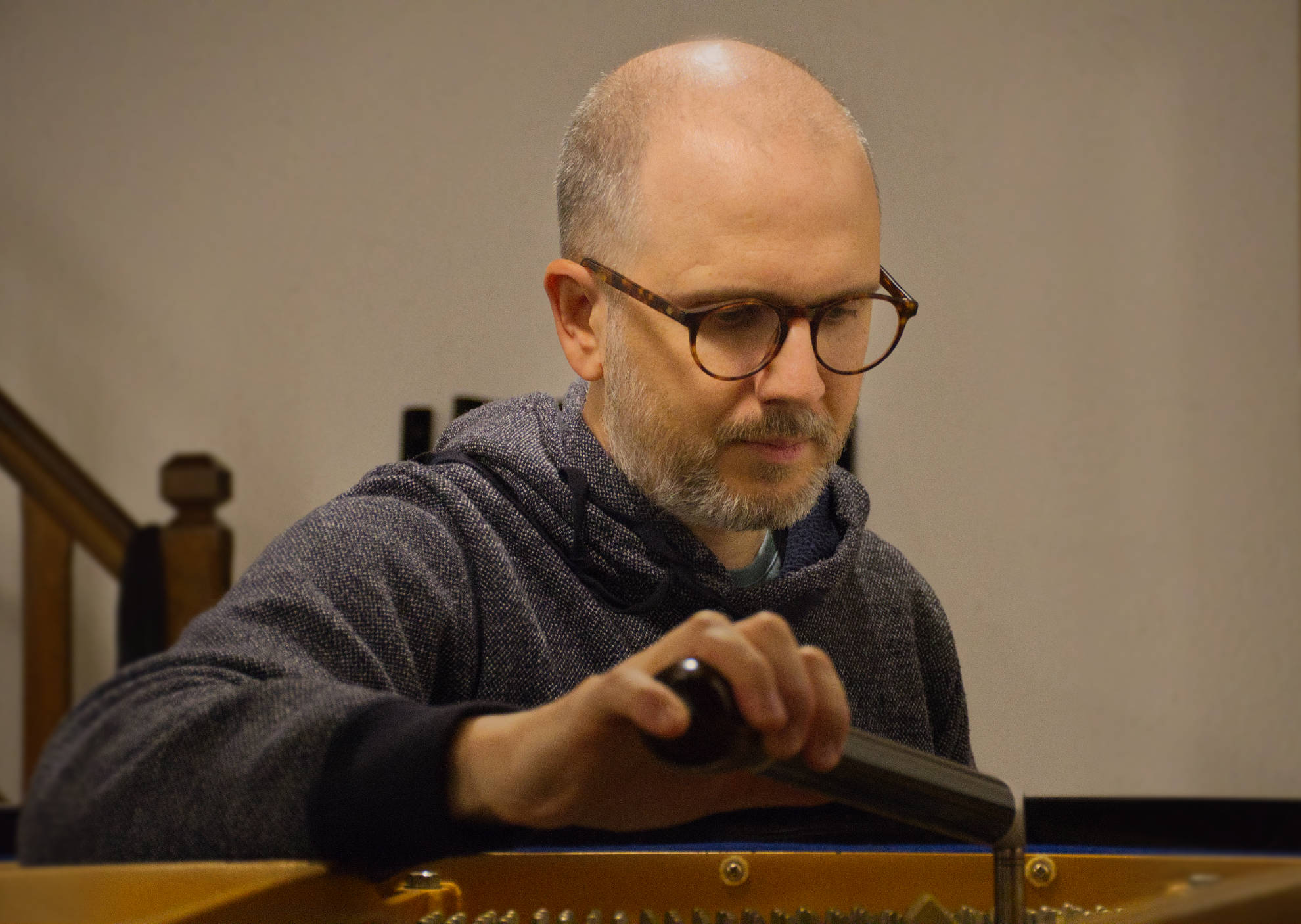 Benjamin Martinez, accordeur de piano à Lyon, en train d'accorder un piano Kawai KG-2D
